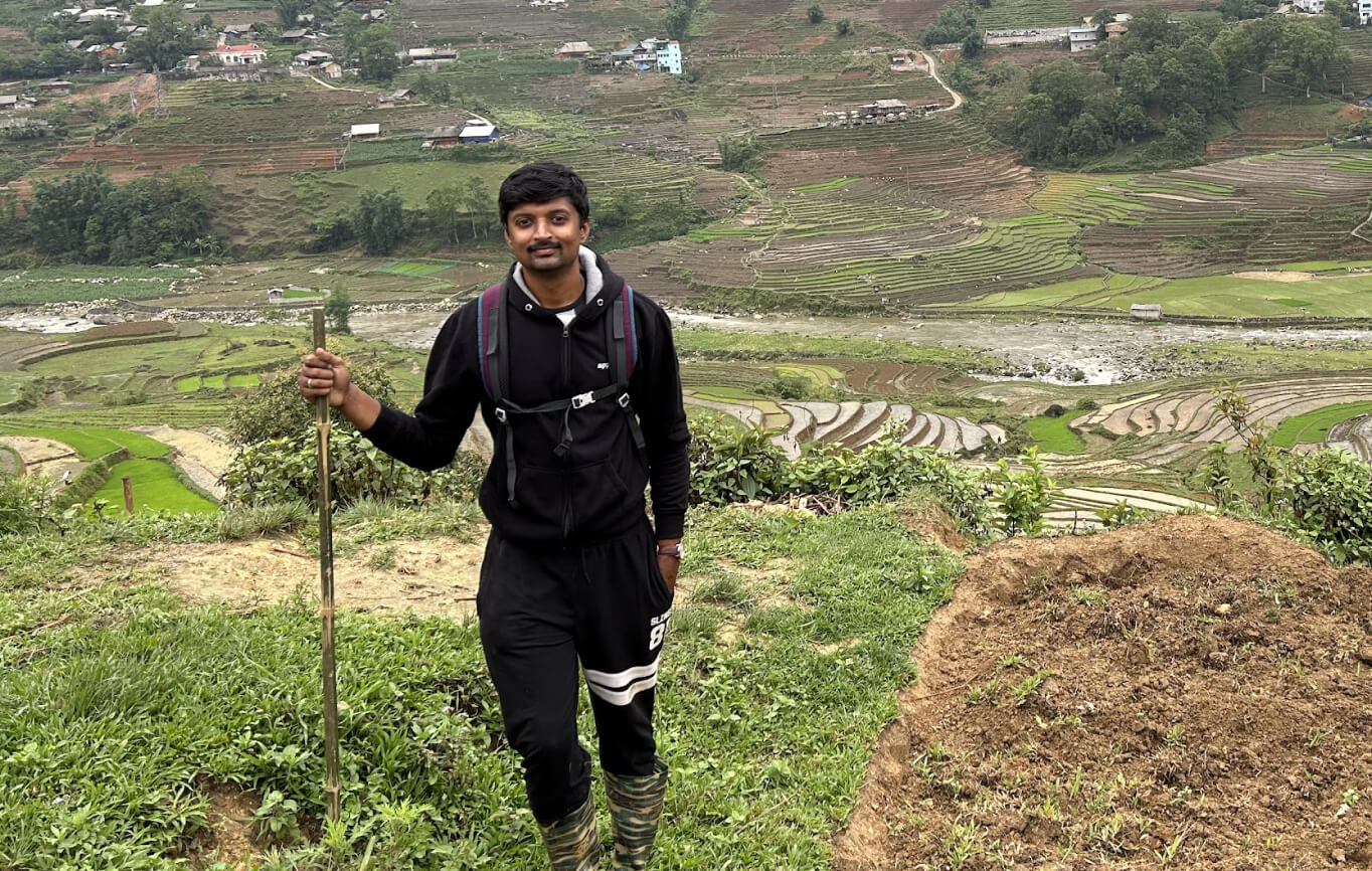 Vasanth hiking above green terraced fields