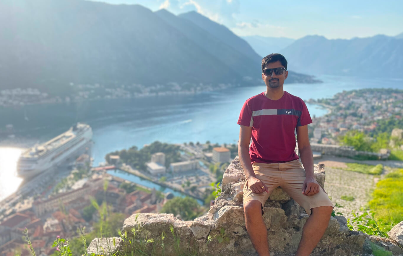 Vasanth overlooking a coastal town and mountains
